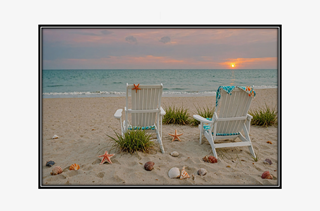beach chairs with seashells by shore watching sunset