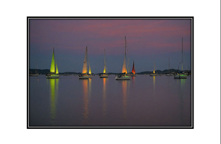 lit up sailboats in the bay